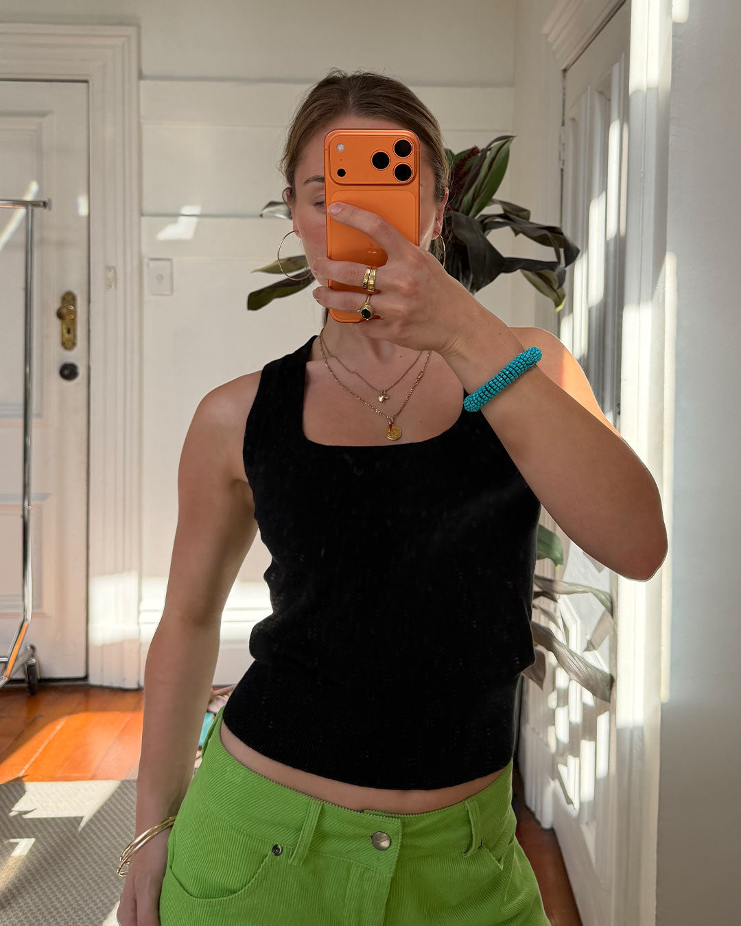 Women's black knit sleeveless top with scoop neck and cinched ribbed wasist band