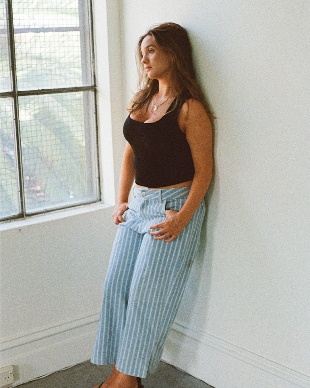 Women's black knit sleeveless top with scoop neck and cinched ribbed wasist band