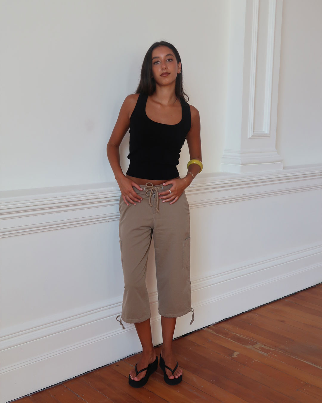 Women's black knit sleeveless top with scoop neck and cinched ribbed wasist band