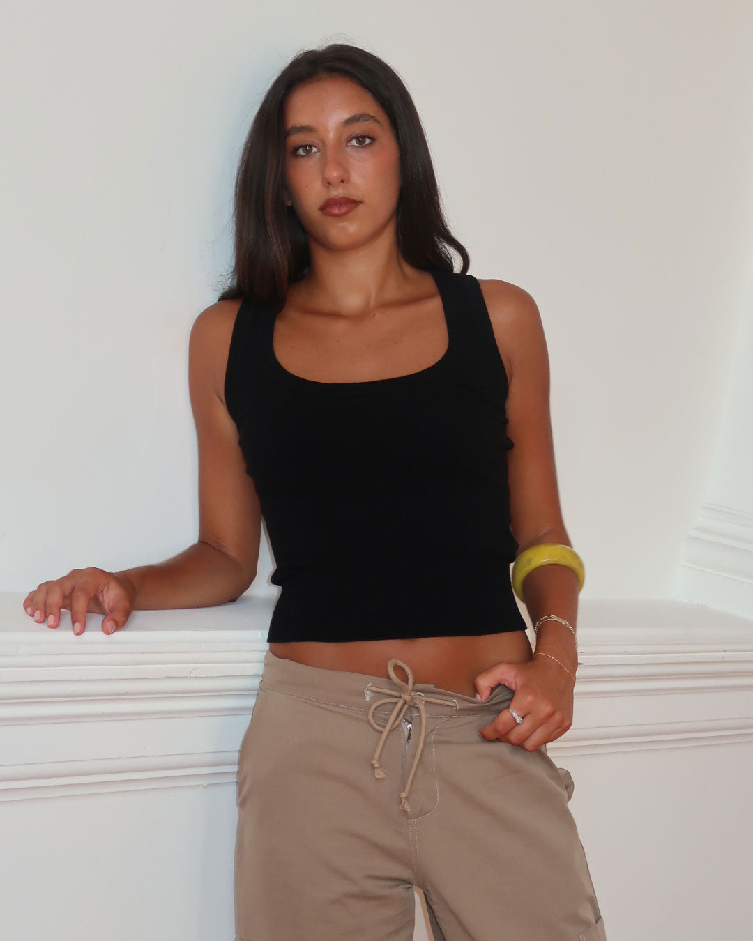 Women's black knit sleeveless top with scoop neck and cinched ribbed wasist band