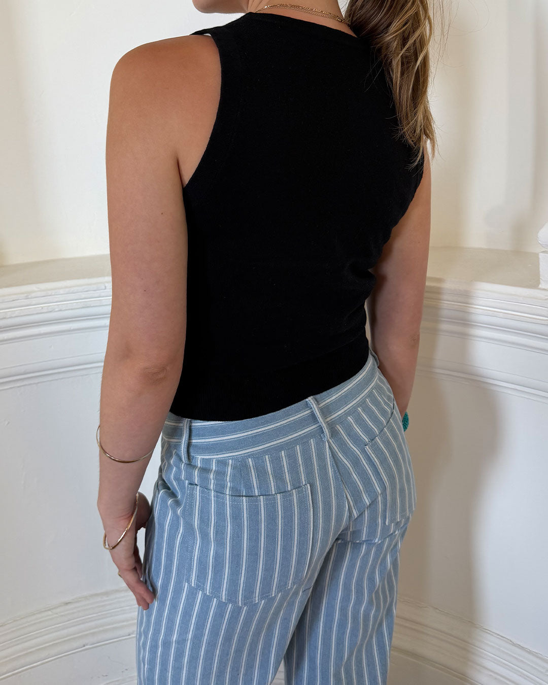 Women's black knit sleeveless top with scoop neck and cinched ribbed wasist band