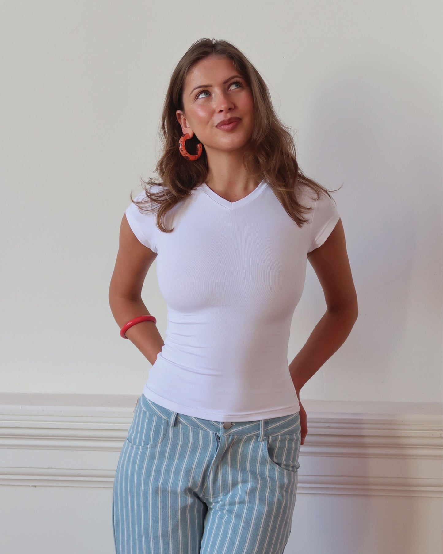 Women's 90s inspired tee in white with soft high V neck and a figure hugging fit. 