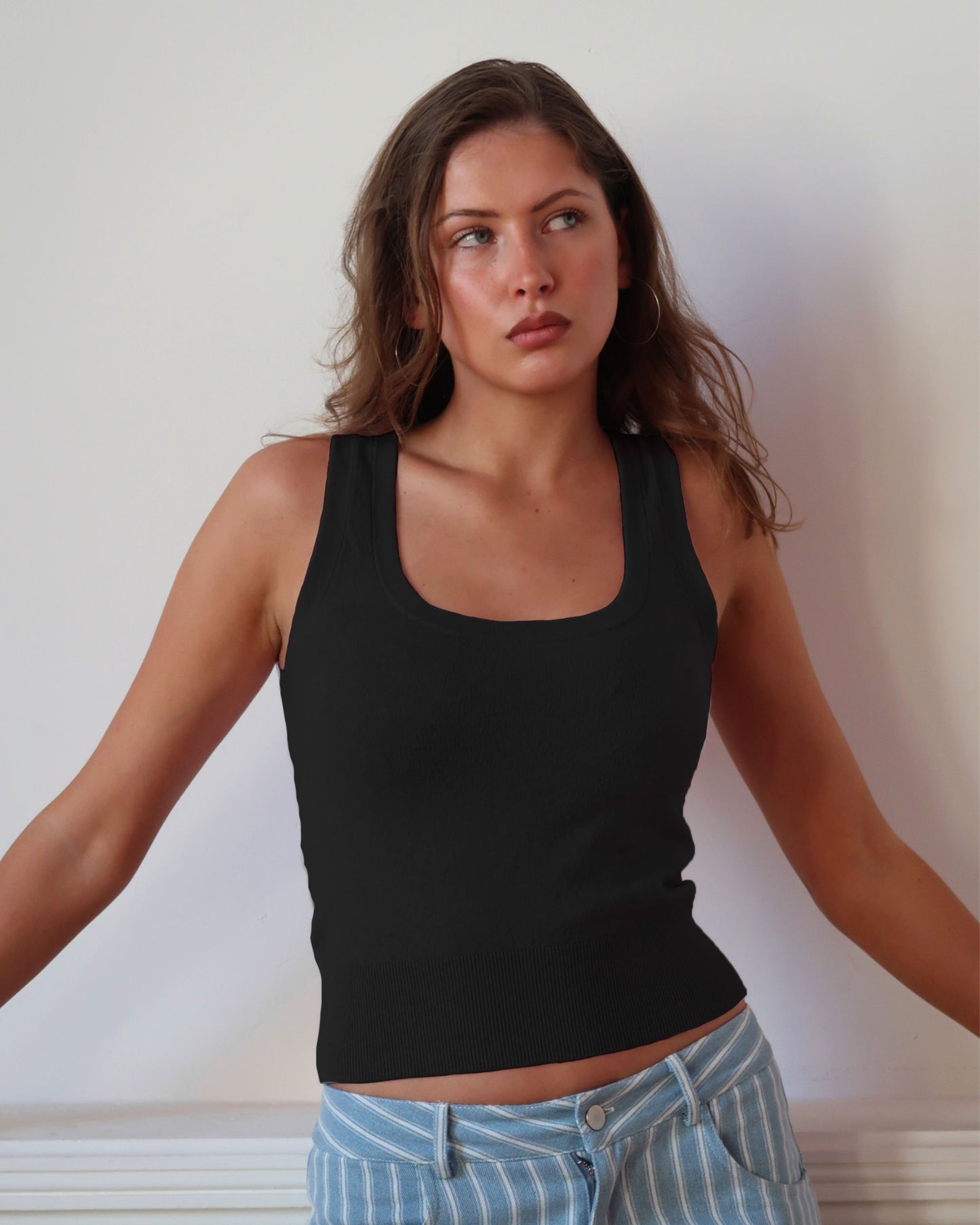 Women's black knit sleeveless top with scoop neck and cinched ribbed wasist band